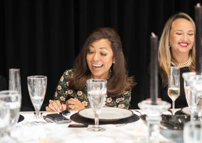 Woman speaking while enjoying a formal dinner.