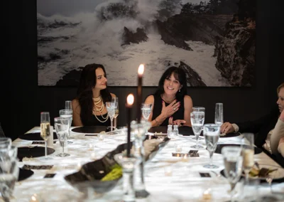 Two women at a formal dinner table.