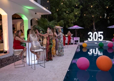 Group of women sitting and standing by pool.