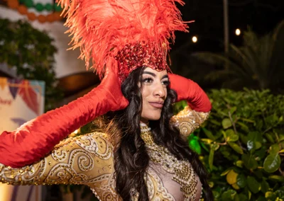Performer with feather hat a Brazilian carnivale themed outdoor party.