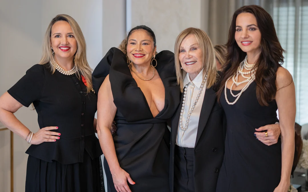 Group of women smiling wearing beautiful black outfits.